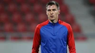 Mid-30s Vålerenga midfielder, athletic build, waist-up, intense gaze, drenched in sweat, wearing a plain blue and red...
